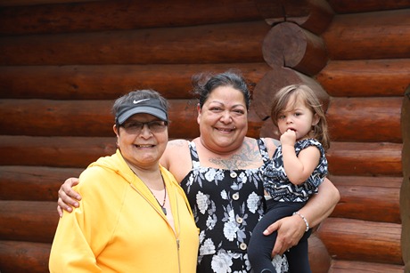 Two First Nation women and one holding their child for a portait