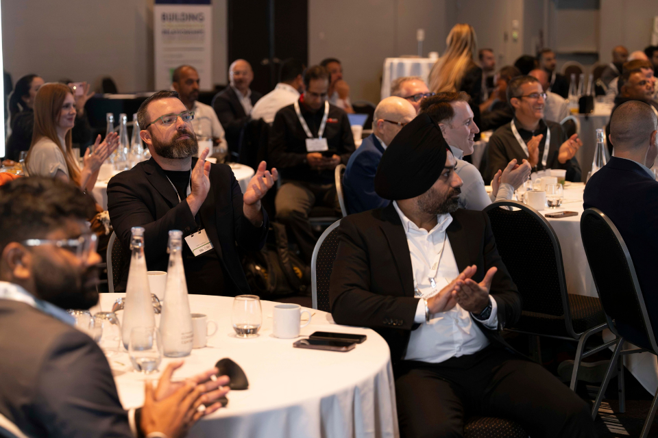 individuals clapping at the EMEA 2026 event.