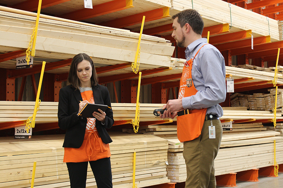Employees assessing energy use in the lumber aisle of the Home Depot