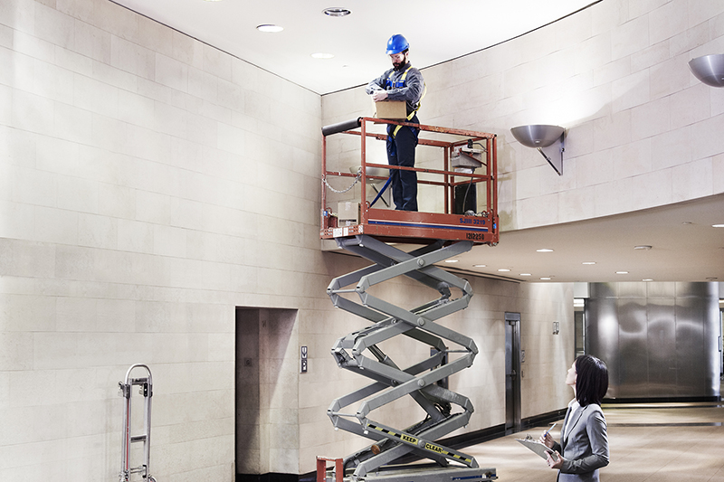 Contractor retrofitting lights in the lobby of a building