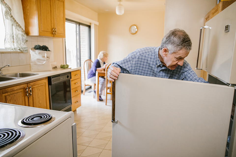 Elderly man opening fridge