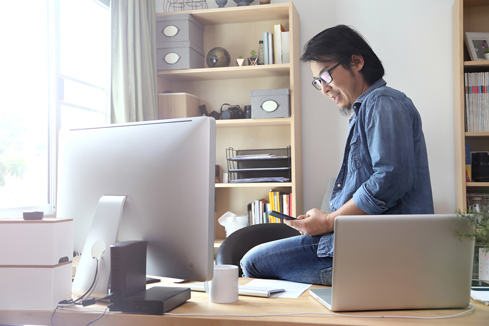 man sitting on desk in home office